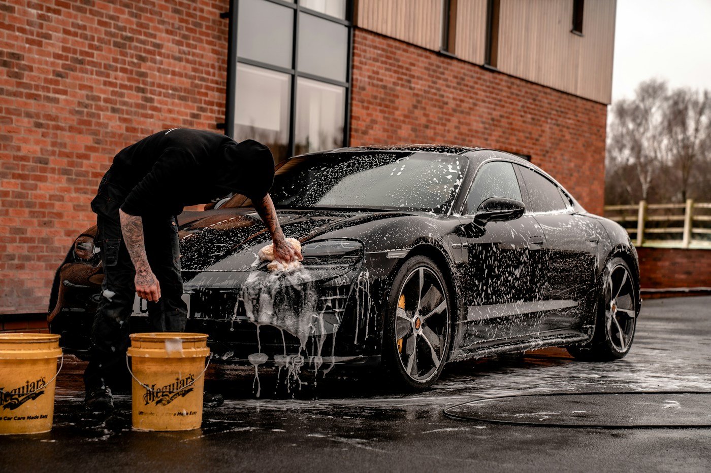 A detailer cleaning the exterior of a vehicle